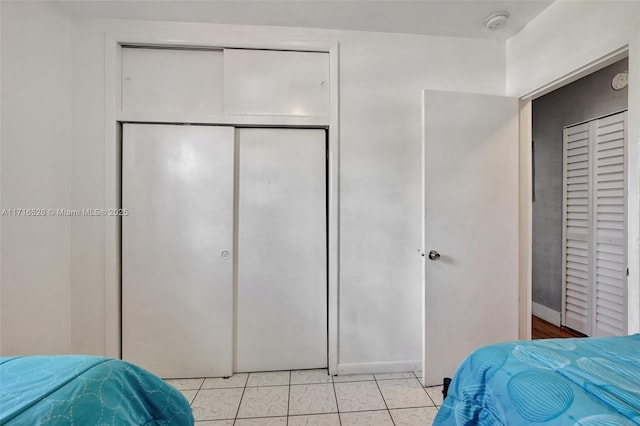 bedroom featuring light tile patterned floors and a closet