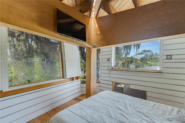 bedroom with radiator heating unit, wood-type flooring, and wood walls