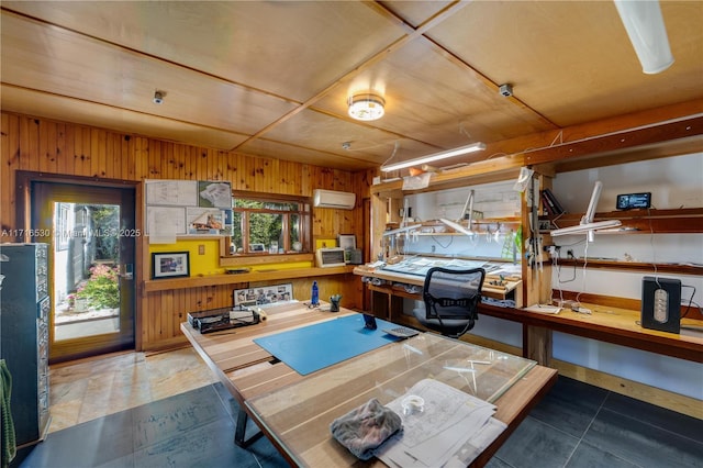 interior space featuring an AC wall unit, tile patterned flooring, a workshop area, and wood walls