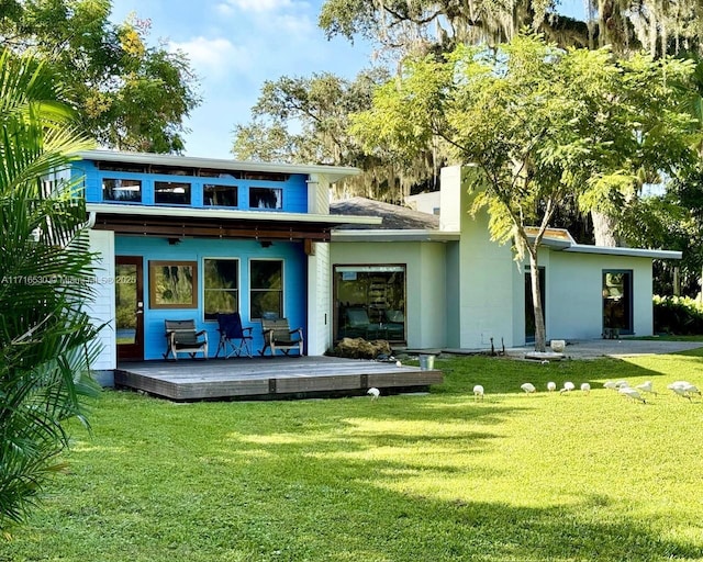 back of house featuring a wooden deck and a yard