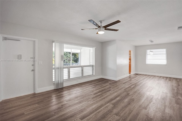 unfurnished room with a healthy amount of sunlight, baseboards, and wood finished floors