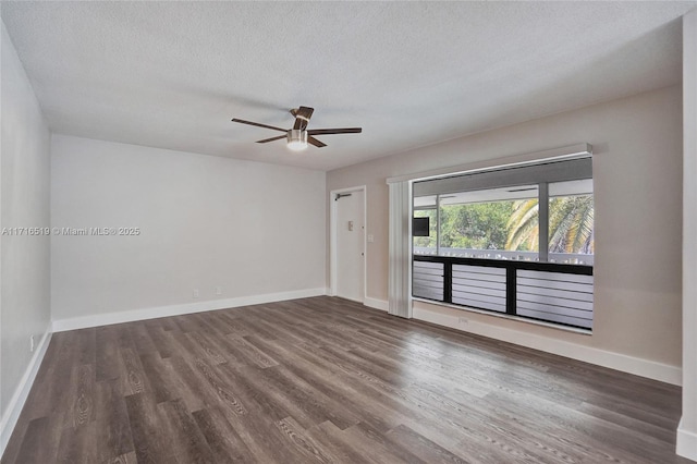 spare room featuring baseboards and wood finished floors