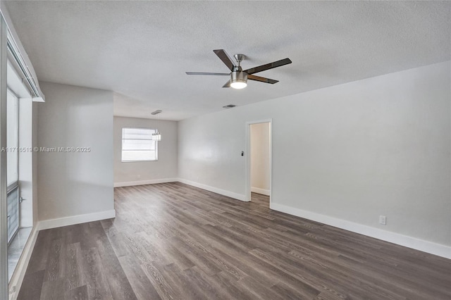 unfurnished room with a textured ceiling, ceiling fan, visible vents, baseboards, and dark wood finished floors