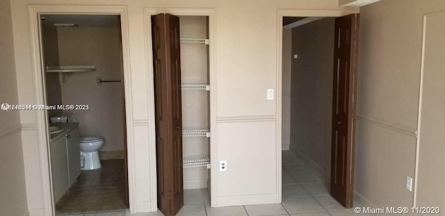 bathroom featuring toilet, tile patterned flooring, and vanity