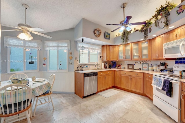 kitchen with a textured ceiling, ceiling fan, white appliances, and sink