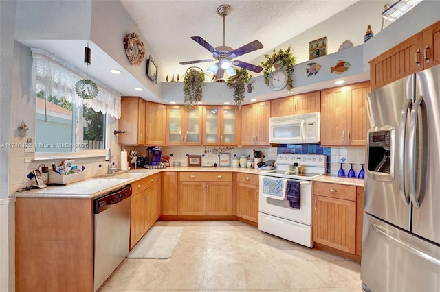 kitchen featuring a textured ceiling, stainless steel appliances, ceiling fan, sink, and light tile patterned floors