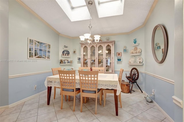 tiled dining room with a skylight, an inviting chandelier, a textured ceiling, and ornamental molding