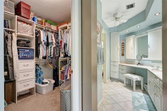 spacious closet with ceiling fan and light tile patterned floors