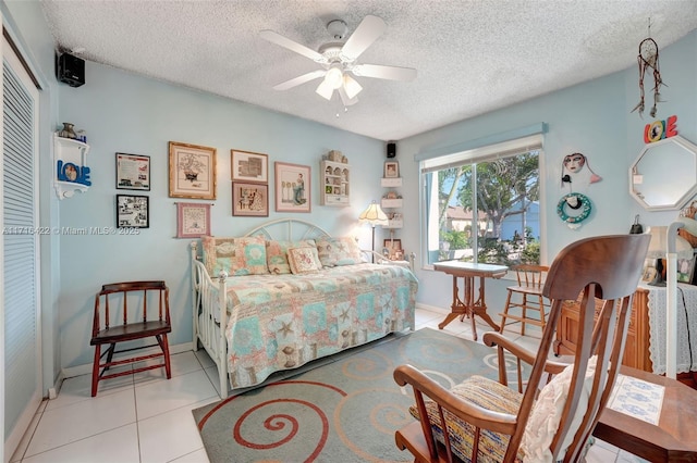 bedroom featuring light tile patterned floors, a textured ceiling, and ceiling fan