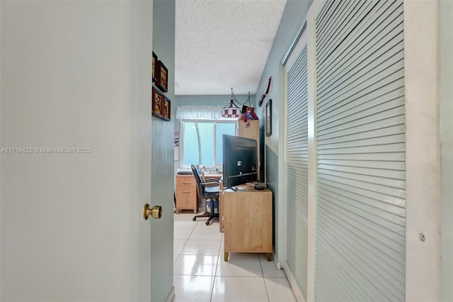 hallway with light tile patterned floors and a textured ceiling