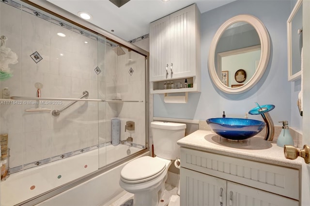 full bathroom featuring vanity, enclosed tub / shower combo, and toilet