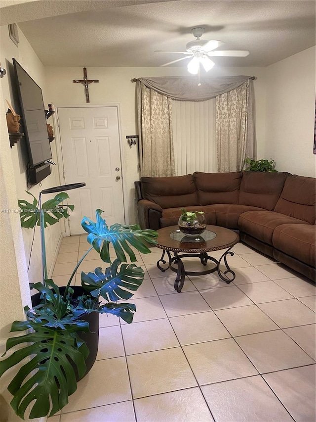 tiled living room featuring ceiling fan and a textured ceiling