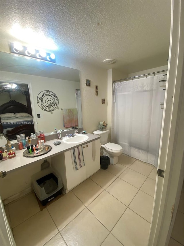 bathroom featuring tile patterned floors, vanity, a textured ceiling, and toilet