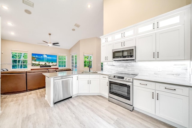 kitchen featuring decorative backsplash, white cabinetry, and appliances with stainless steel finishes