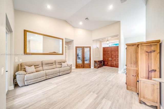 living room featuring vaulted ceiling, light hardwood / wood-style flooring, and french doors