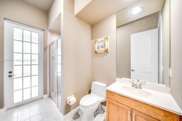 bathroom with tile patterned floors, vanity, toilet, and a shower with door