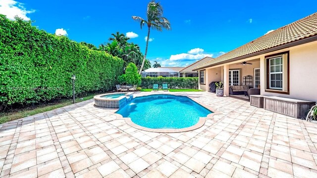 view of pool featuring an in ground hot tub, a patio, and ceiling fan