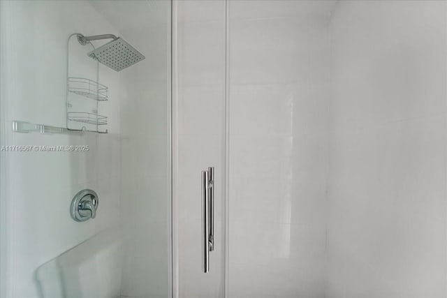 interior details featuring a tile shower