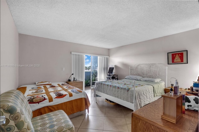 bedroom featuring access to exterior, light tile patterned floors, and a textured ceiling