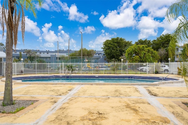 community pool with fence and a patio