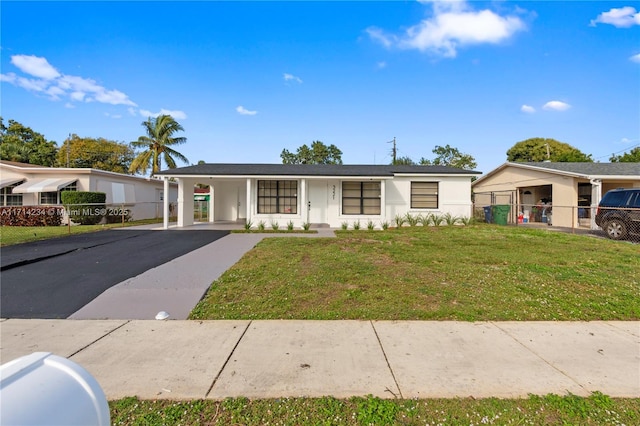 ranch-style home featuring a front yard and a carport