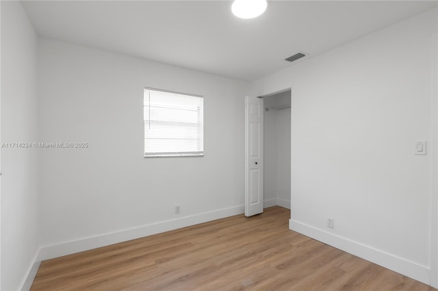 unfurnished bedroom featuring light hardwood / wood-style floors and a closet