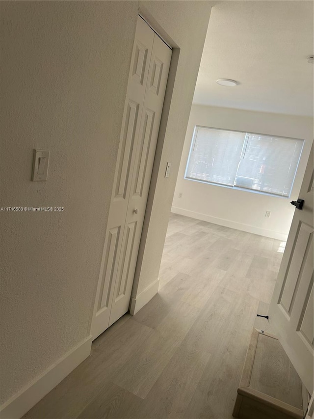 hallway with light hardwood / wood-style flooring