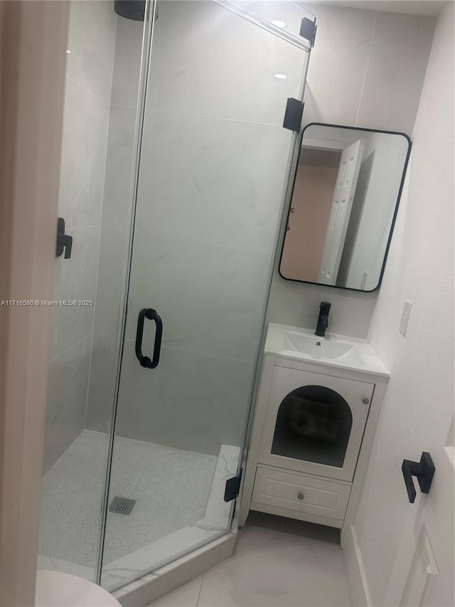 bathroom featuring vanity, toilet, and a shower with shower door