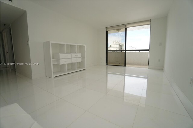 empty room with light tile patterned floors and floor to ceiling windows