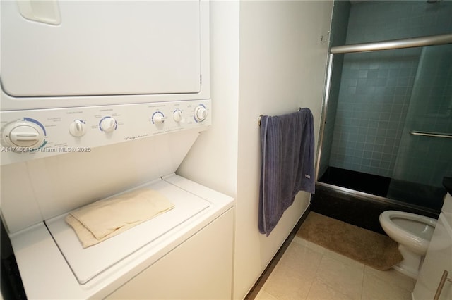 clothes washing area with laundry area, light tile patterned floors, and stacked washer / drying machine