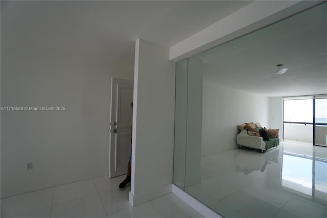 bathroom with floor to ceiling windows and tile patterned floors