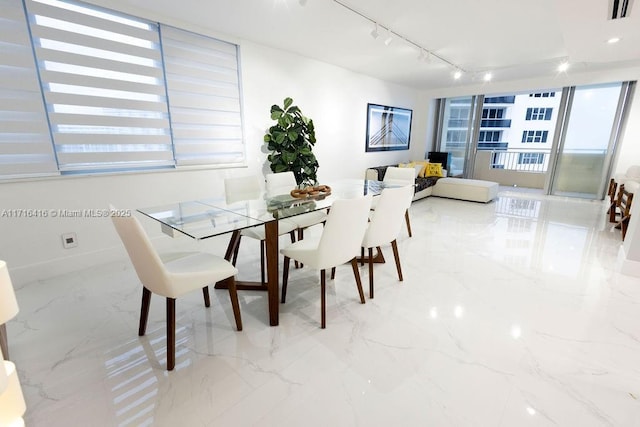 dining space with visible vents, baseboards, marble finish floor, and rail lighting