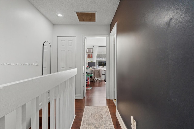 hallway with dark hardwood / wood-style flooring and a textured ceiling