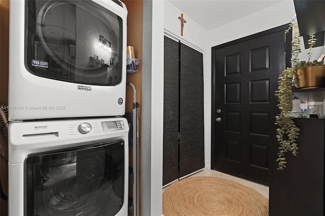 clothes washing area with stacked washer / dryer