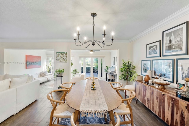 dining space with ornamental molding, dark wood-type flooring, a textured ceiling, and an inviting chandelier