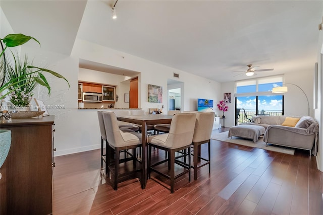 dining space featuring ceiling fan and dark hardwood / wood-style flooring