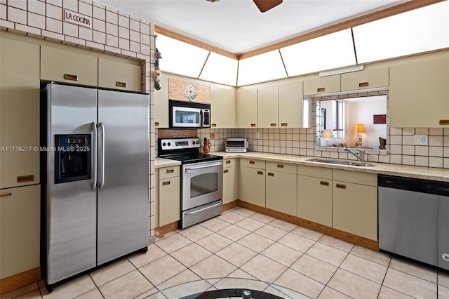 kitchen featuring sink, ceiling fan, tasteful backsplash, cream cabinetry, and stainless steel appliances