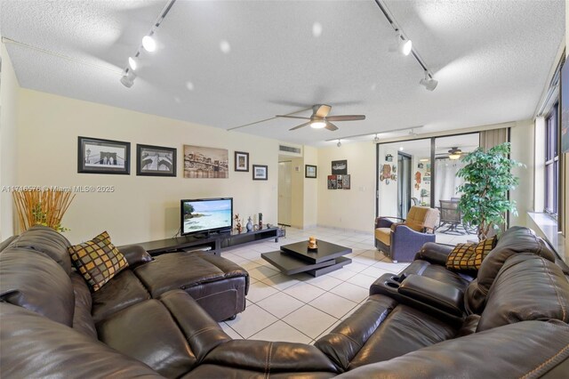 living room with rail lighting, light tile patterned flooring, and a textured ceiling