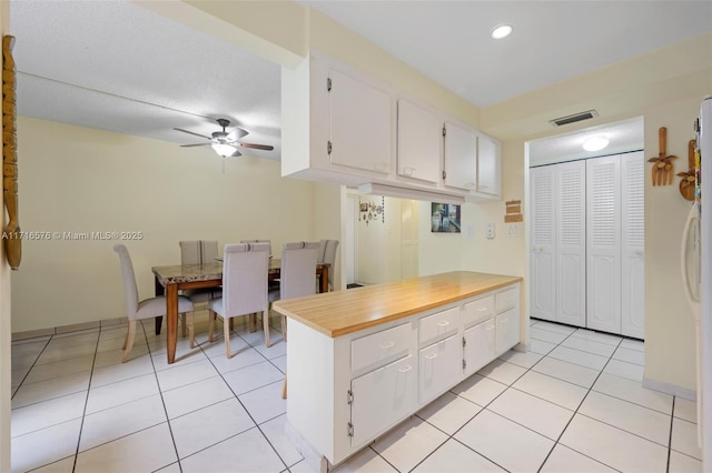 kitchen featuring white cabinetry, ceiling fan, and light tile patterned floors