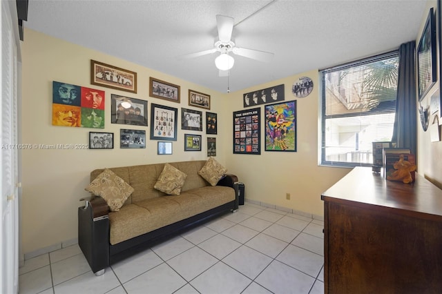 tiled living room featuring ceiling fan and a textured ceiling