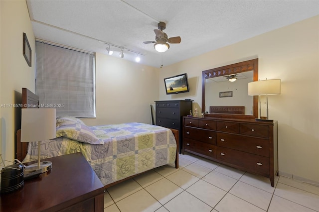 bedroom with ceiling fan, rail lighting, light tile patterned flooring, and a textured ceiling