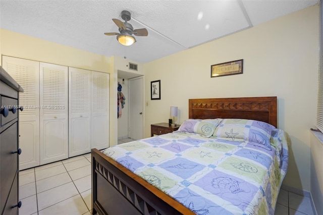 tiled bedroom with a textured ceiling, a closet, and ceiling fan