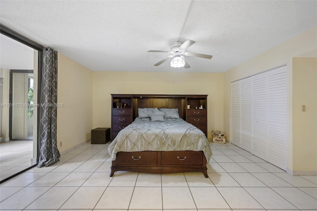 tiled bedroom with ceiling fan, a closet, and a textured ceiling