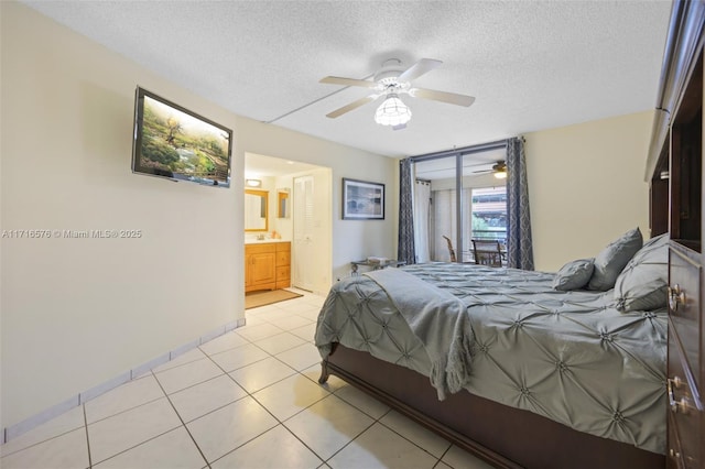 bedroom featuring a textured ceiling, ceiling fan, light tile patterned floors, and ensuite bathroom