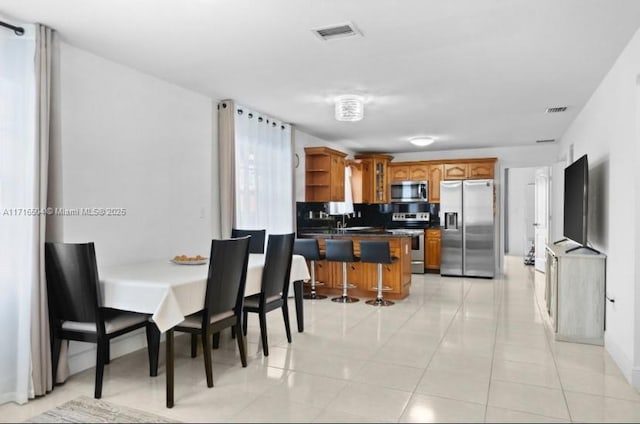 dining area featuring sink and light tile patterned floors