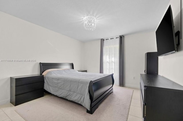 bedroom featuring light tile patterned flooring and an inviting chandelier