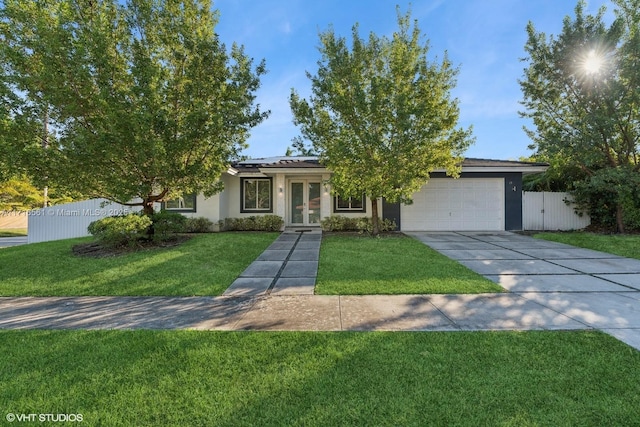 view of front of home featuring a front lawn, solar panels, a garage, and french doors