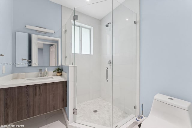 bathroom featuring vanity, toilet, and a shower with door