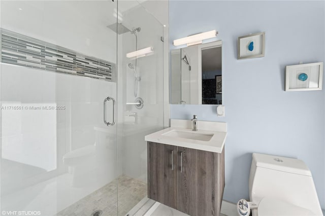 bathroom with vanity, toilet, and a shower with shower door