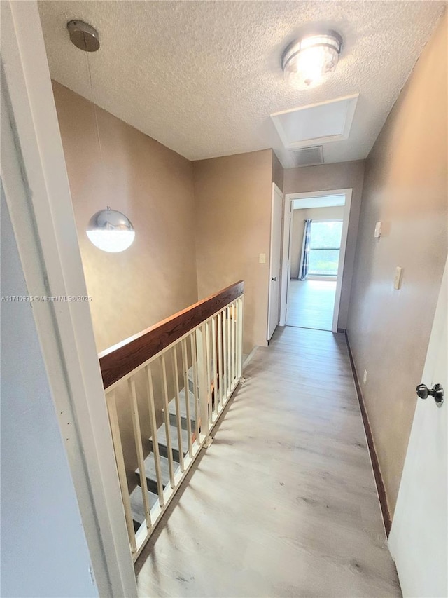 corridor featuring a textured ceiling and hardwood / wood-style flooring